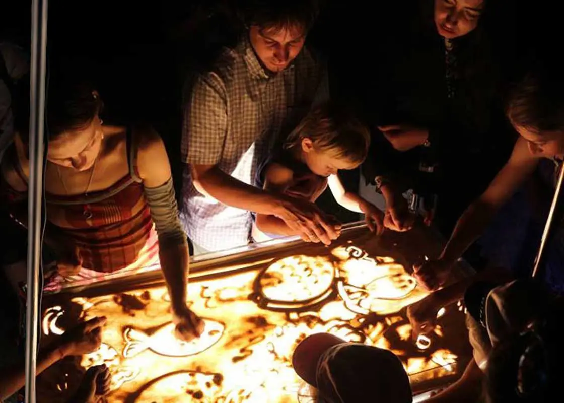 Sand artist conducting sand painting classes for adults and children in London