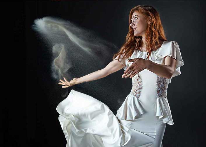 Sand artist tossing sand into the air during a live performance