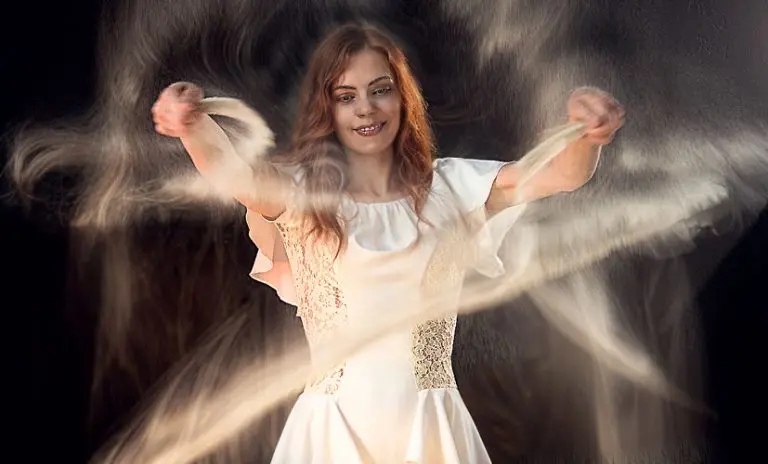 Sand animation artist Daria Tym creating dynamic swirling sand effects on light table during live performance