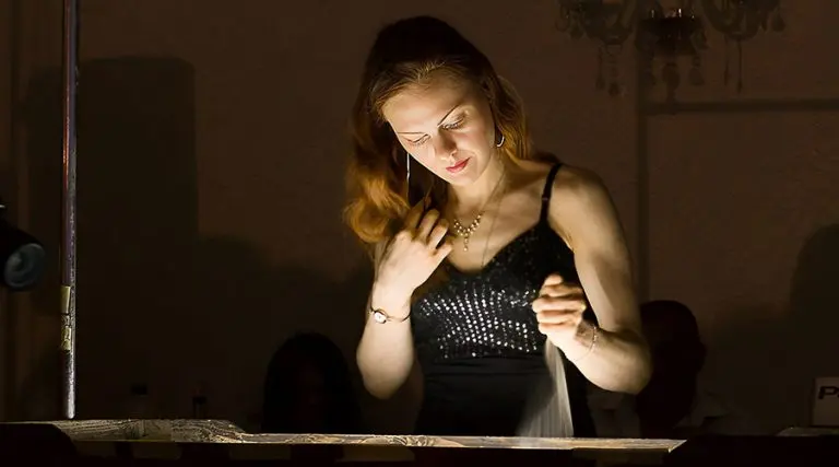 Sand animation artist Daria Tym creating live sand drawing on light table during performance